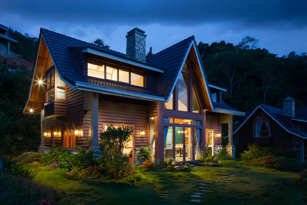 Timber-clad house with warm interior lighting in the evening
